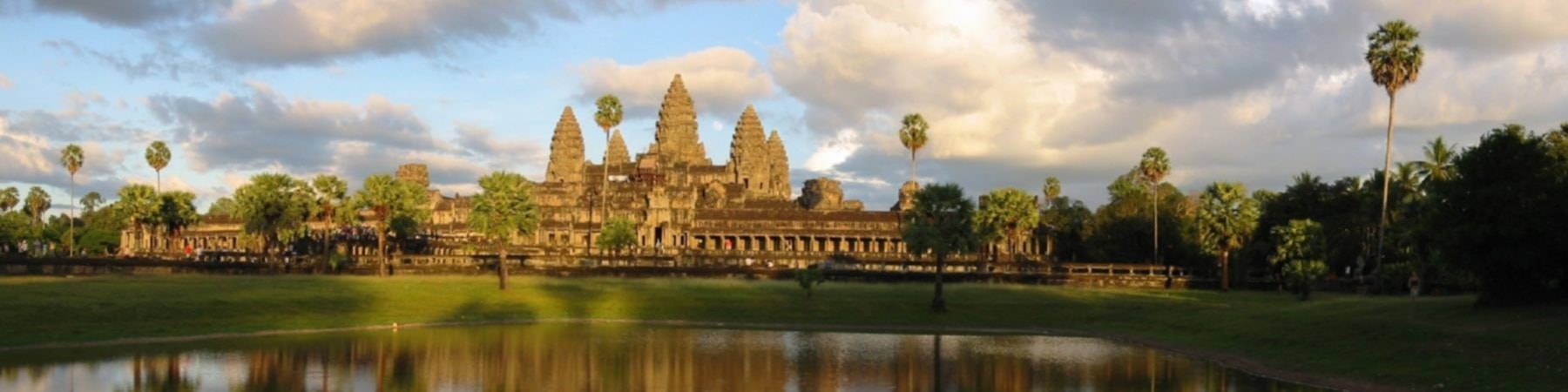 Angkor Wat reflected in water under a bright Cambodian sky